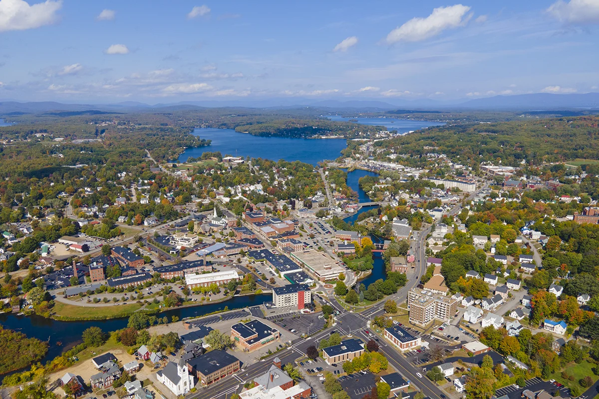 Aerial view of downtown Laconia, New Hampshire with Lake Winnipesaukee in the background.